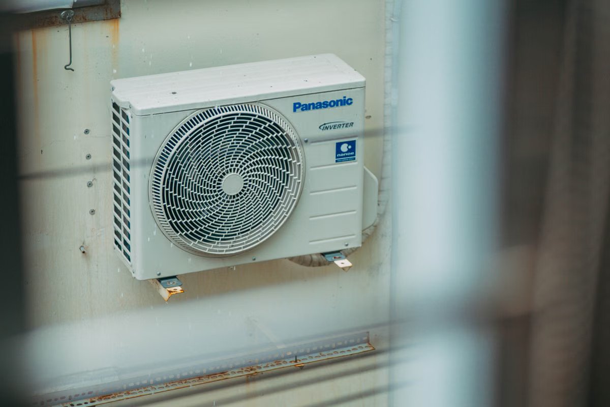 Air source heat pump outdoor unit mounted beside a home